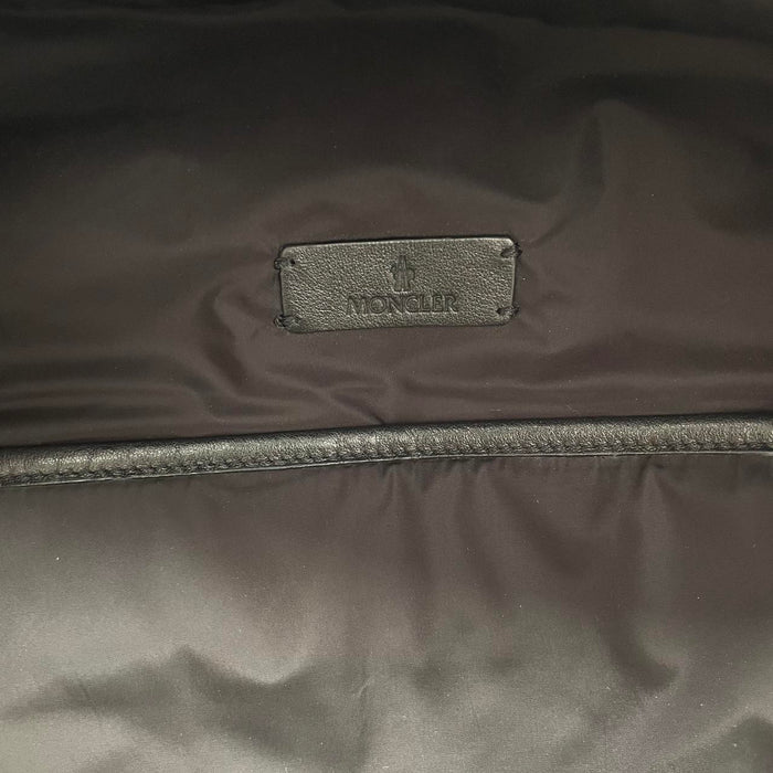 Moncler black duffel bag with logo patch and durable material, pre-loved condition.