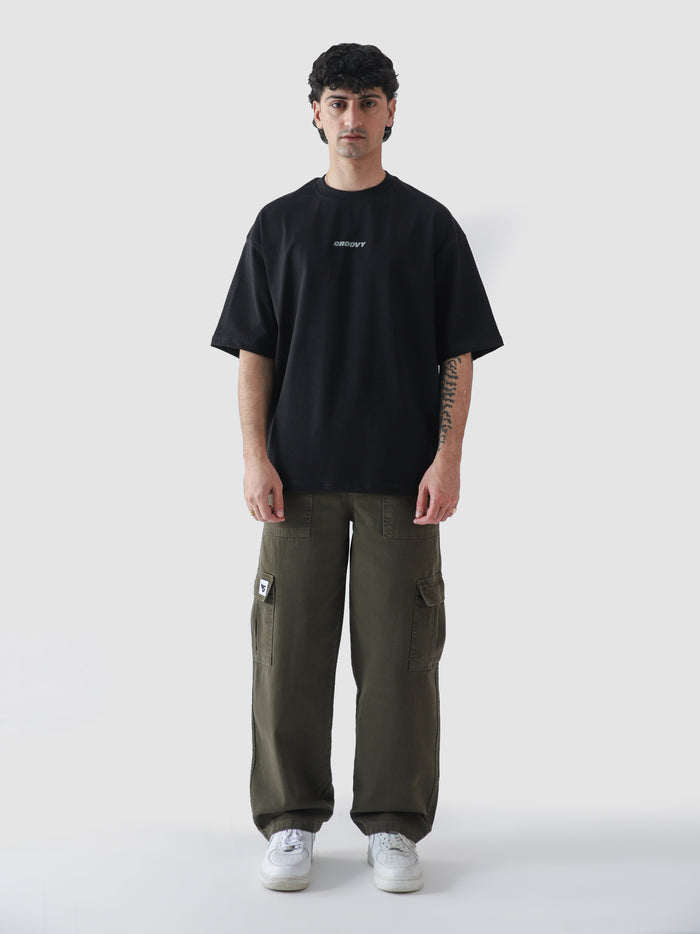 Black oversized essential t-shirt male model full body front Pakistan – GROOVY CORE Tees
