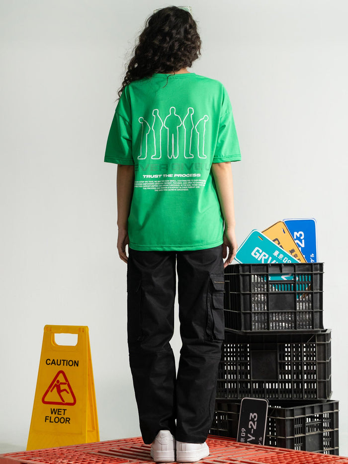 Emerald Green Tee Male Model Seated Lifestyle – Never Give Up – GROOVY Pakistan