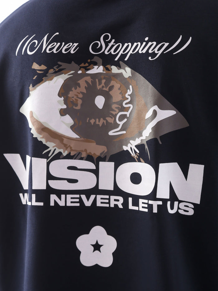Close-up of the back graphic on the "Never Stopping Culture" t-shirt in navy blue, featuring a bold eye illustration and the text “VISION WILL NEVER LET US” in a mix of puff and screen print, representing unshakeable focus and grind culture.