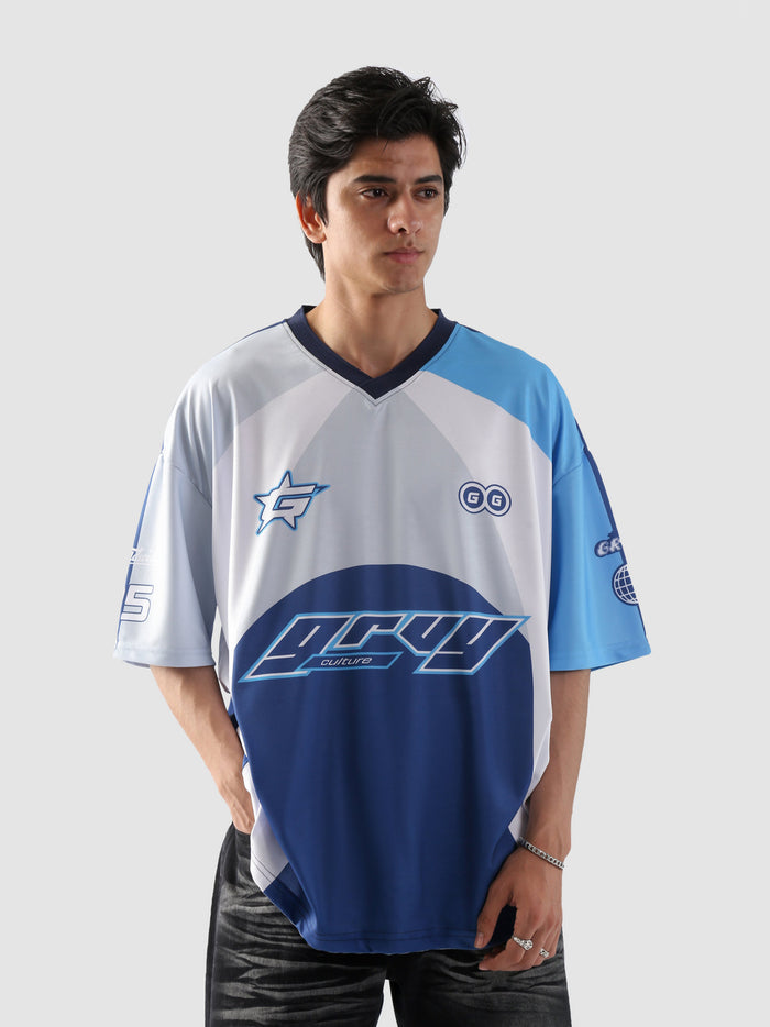 Man wearing oversized blue and white sublimation jersey with racing-inspired graphics – streetwear top by Groovy Culture Pakistan