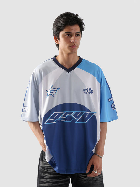 Man wearing oversized blue and white sublimation jersey with racing-inspired graphics – streetwear top by Groovy Culture Pakistan