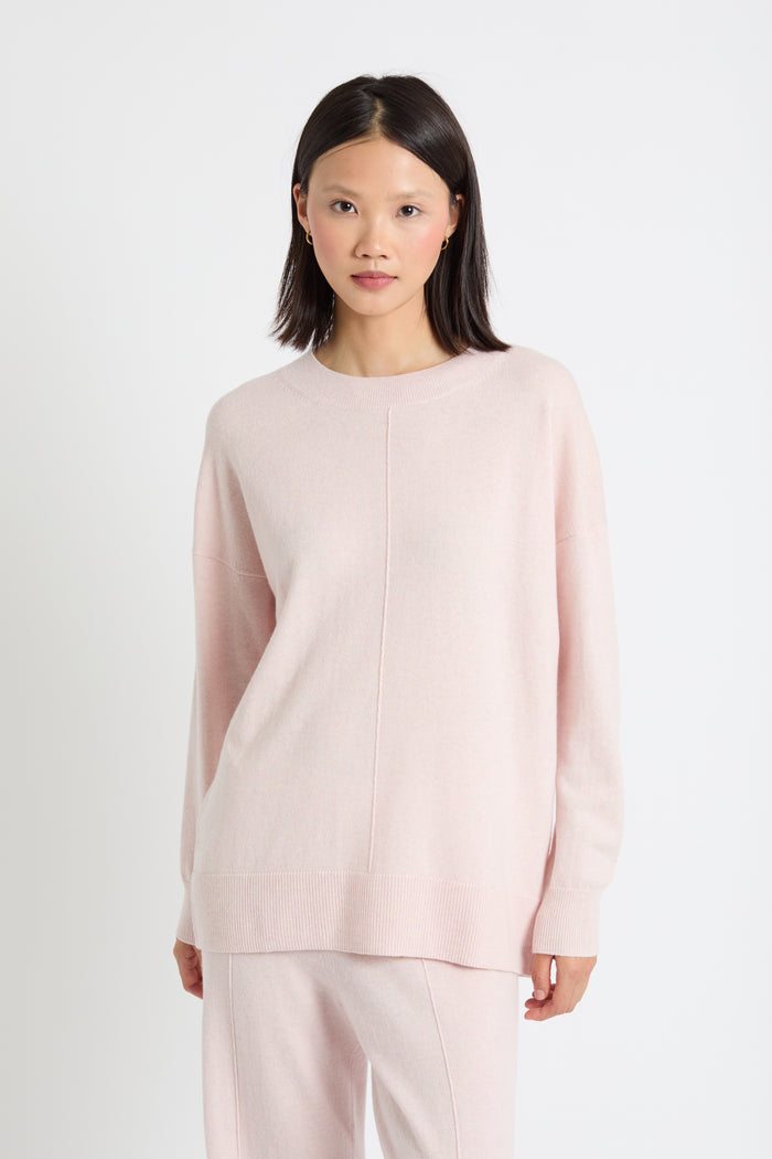 Woman wearing a light pink long-sleeve top and pants on a white background
