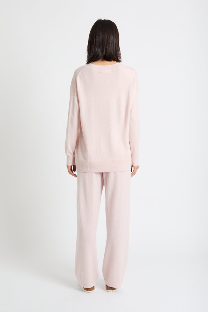 Person wearing a light pink pajama set on a white background