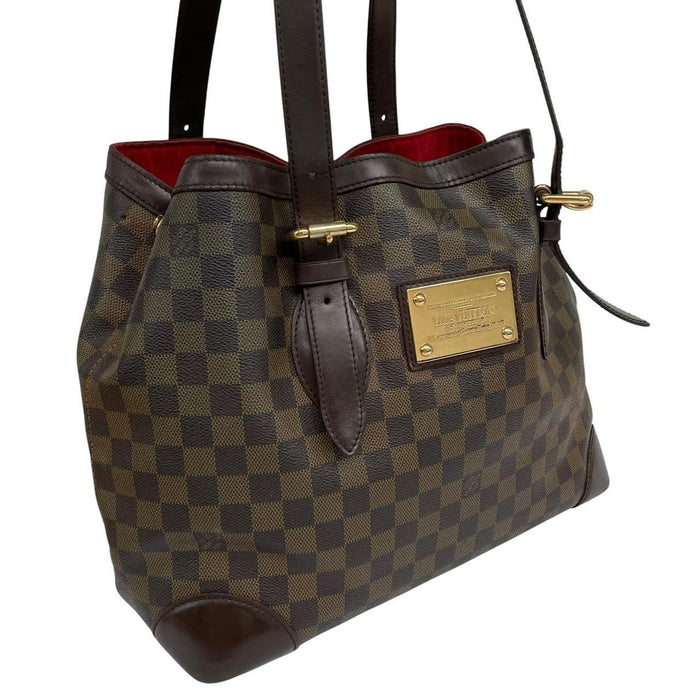 Louis Vuitton brown duffel bag with Damier Ebene pattern and logo plaque details.