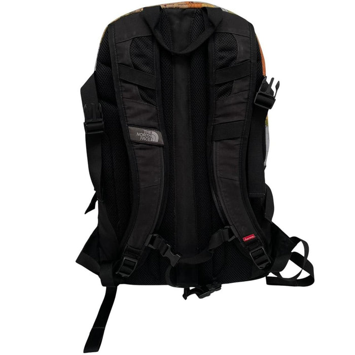 Supreme x The North Face black and multicoloured backpack with logo and scuffed base.