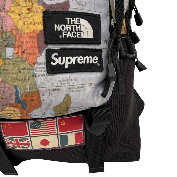 Supreme x The North Face black and multicoloured backpack with logo and scuffed base.