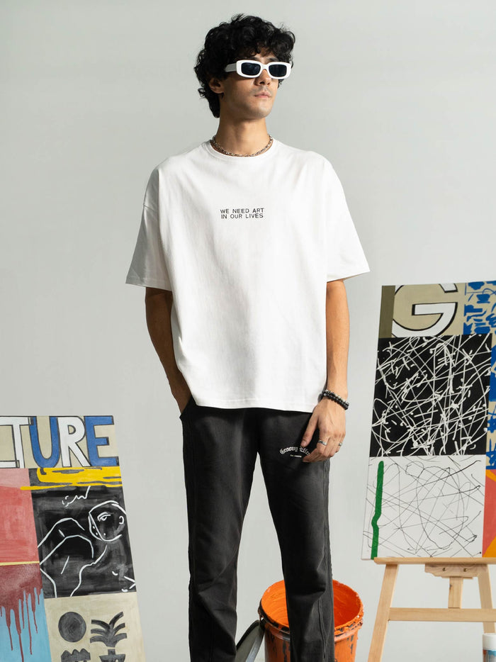 Pearl White Tee Male Model Seated Lifestyle – We Need Art In Our Lives – GROOVY Pakistan